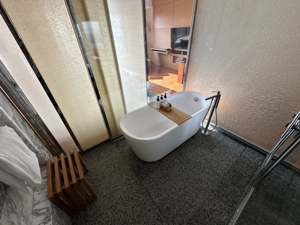 浴槽は独立型です。木のバスボードにボトルを載せられます