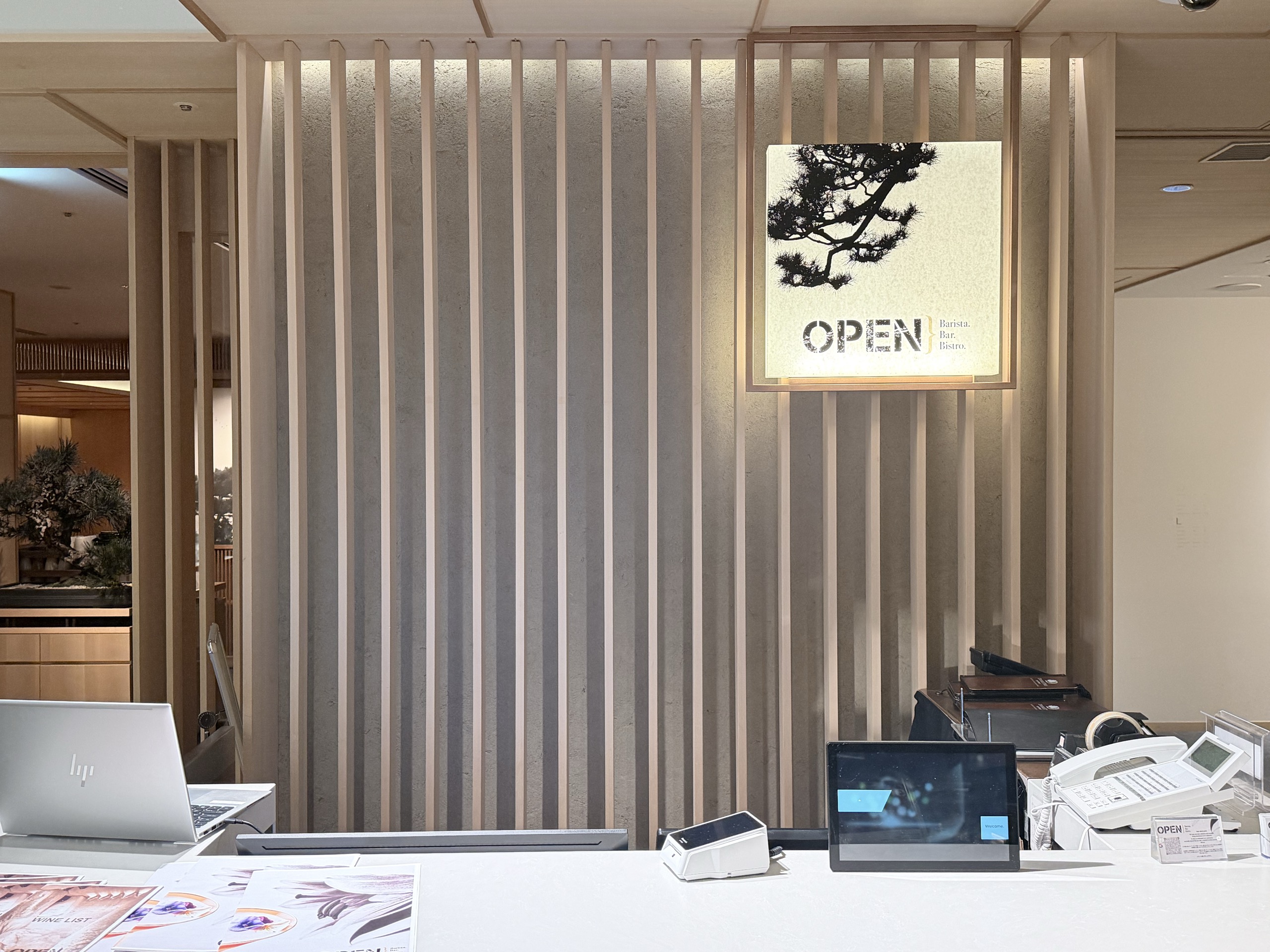 「OPEN」の明かりの看板と、ワインリストが置かれたバーのカウンター