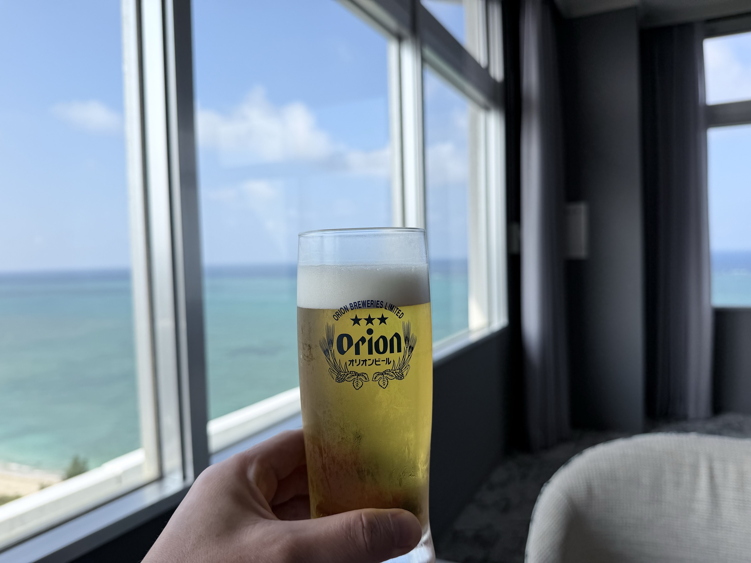 朝のラウンジのオリオンビールと海