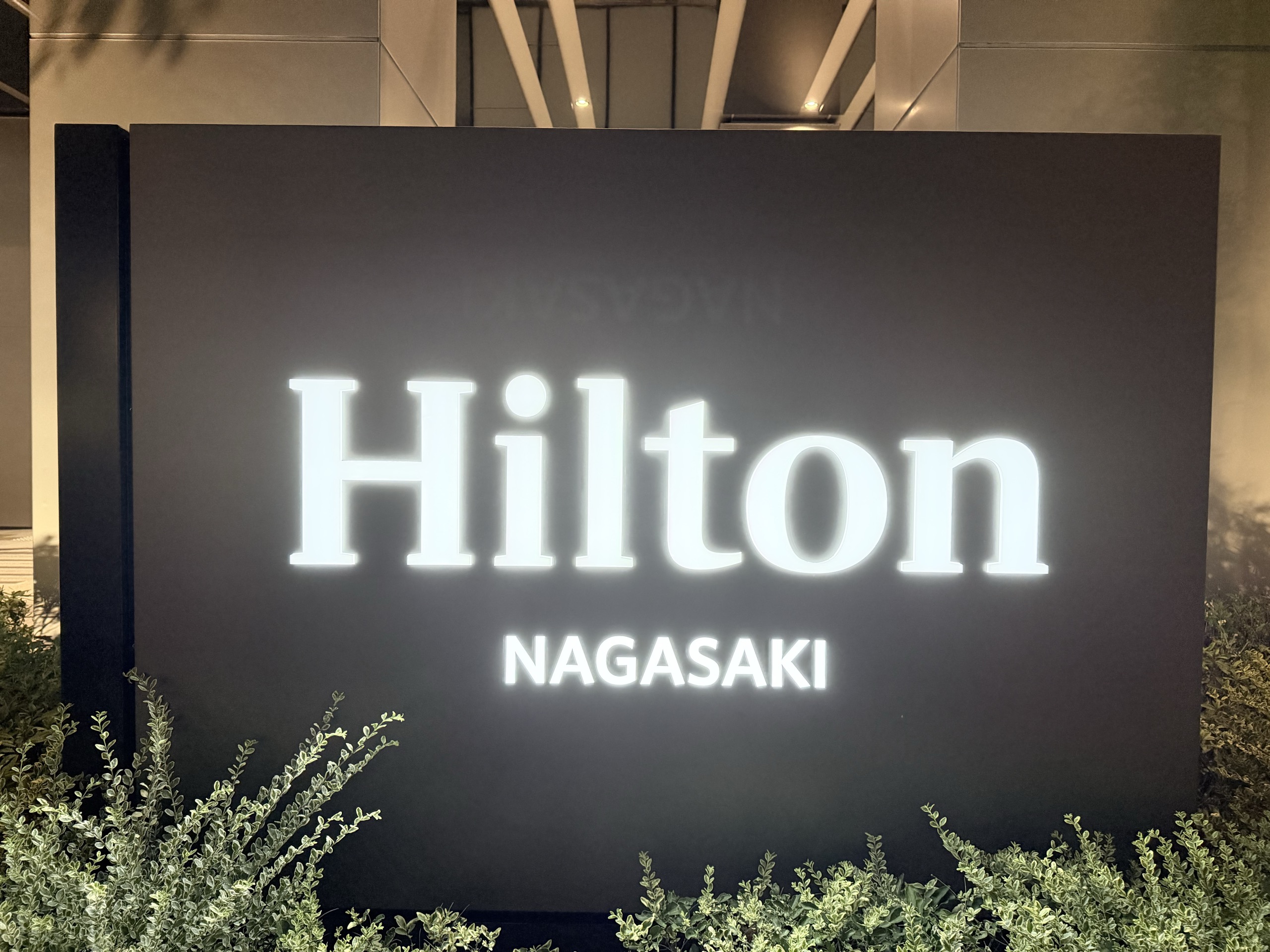 ヒルトン長崎の入口に立つ、ホテルの名前を光らせた黒い立て看板