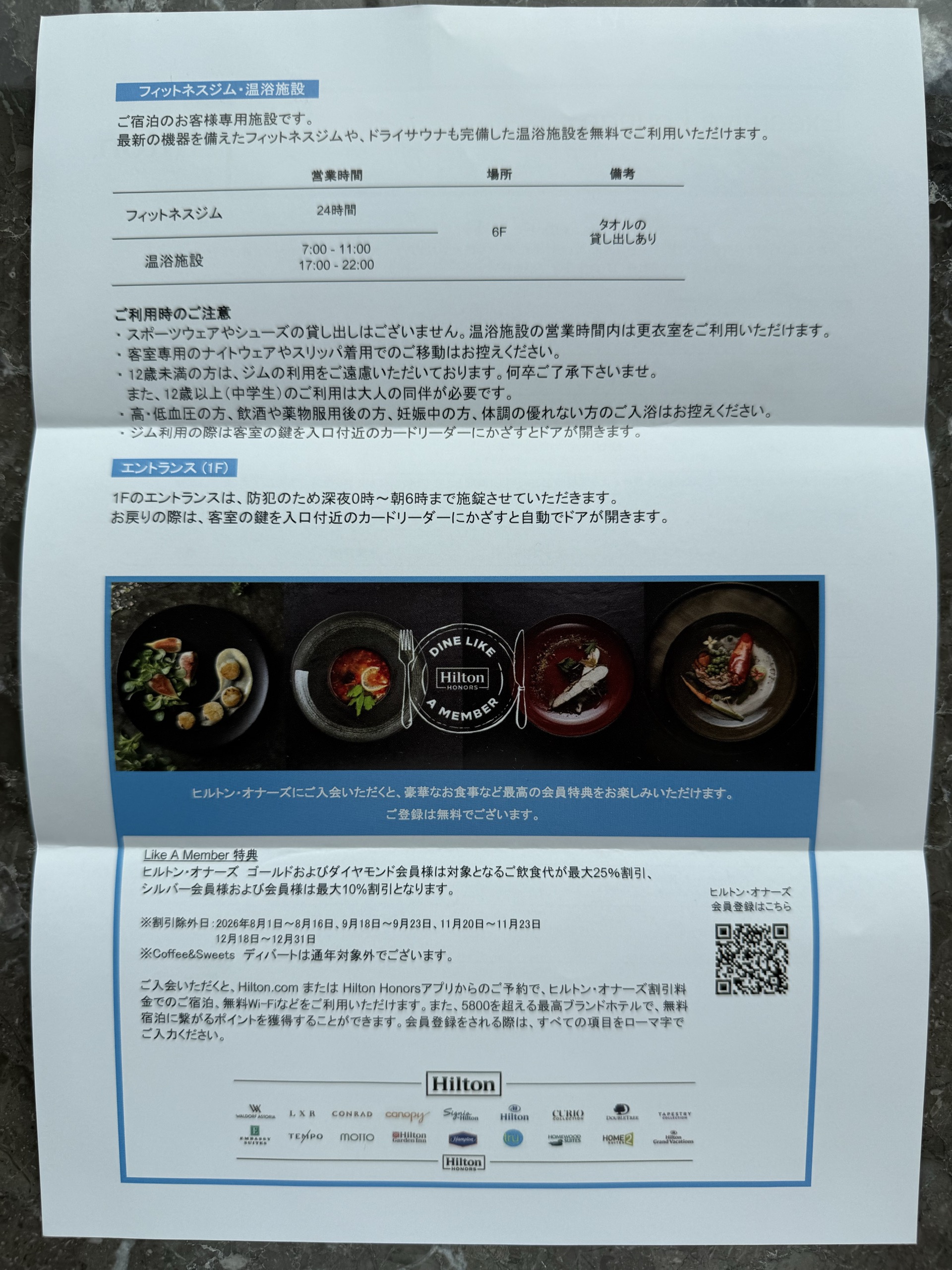 ジムと大浴場の営業時間が書かれた案内の紙