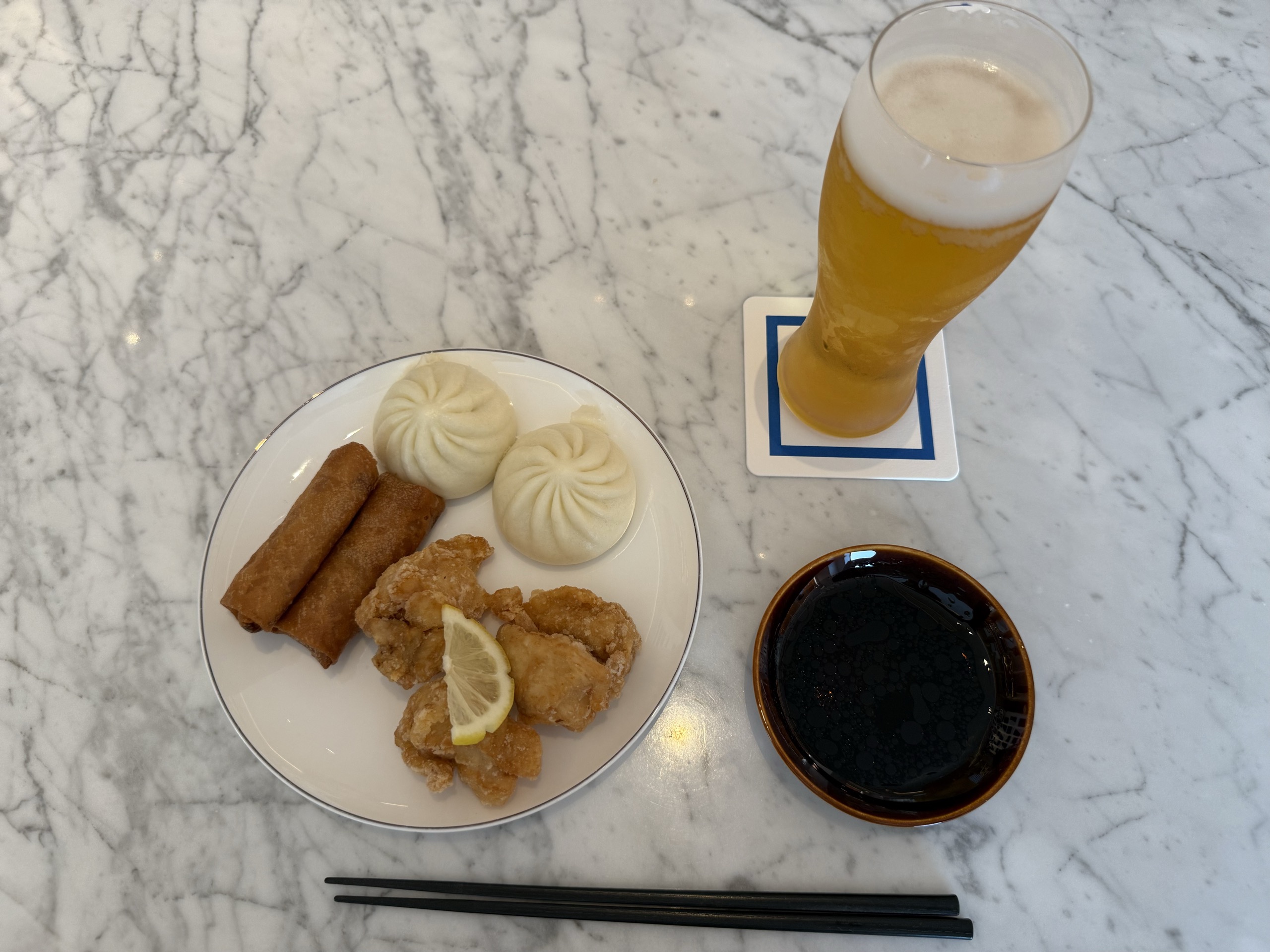 取り分けた揚げ物と肉まん、ビール