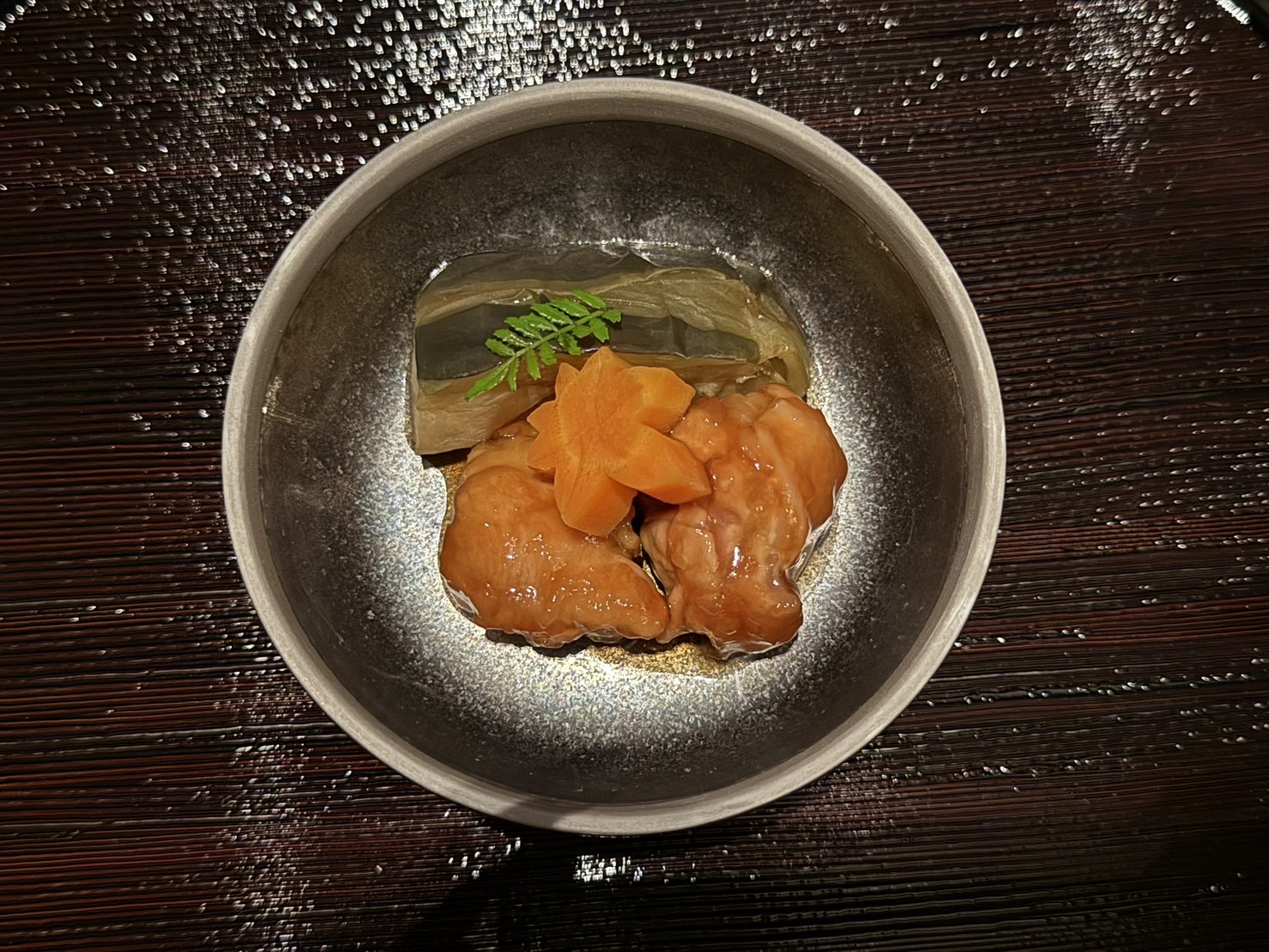 灰色の鉢の、あんをまとった橙色の切り身と、紅葉の形のにんじん