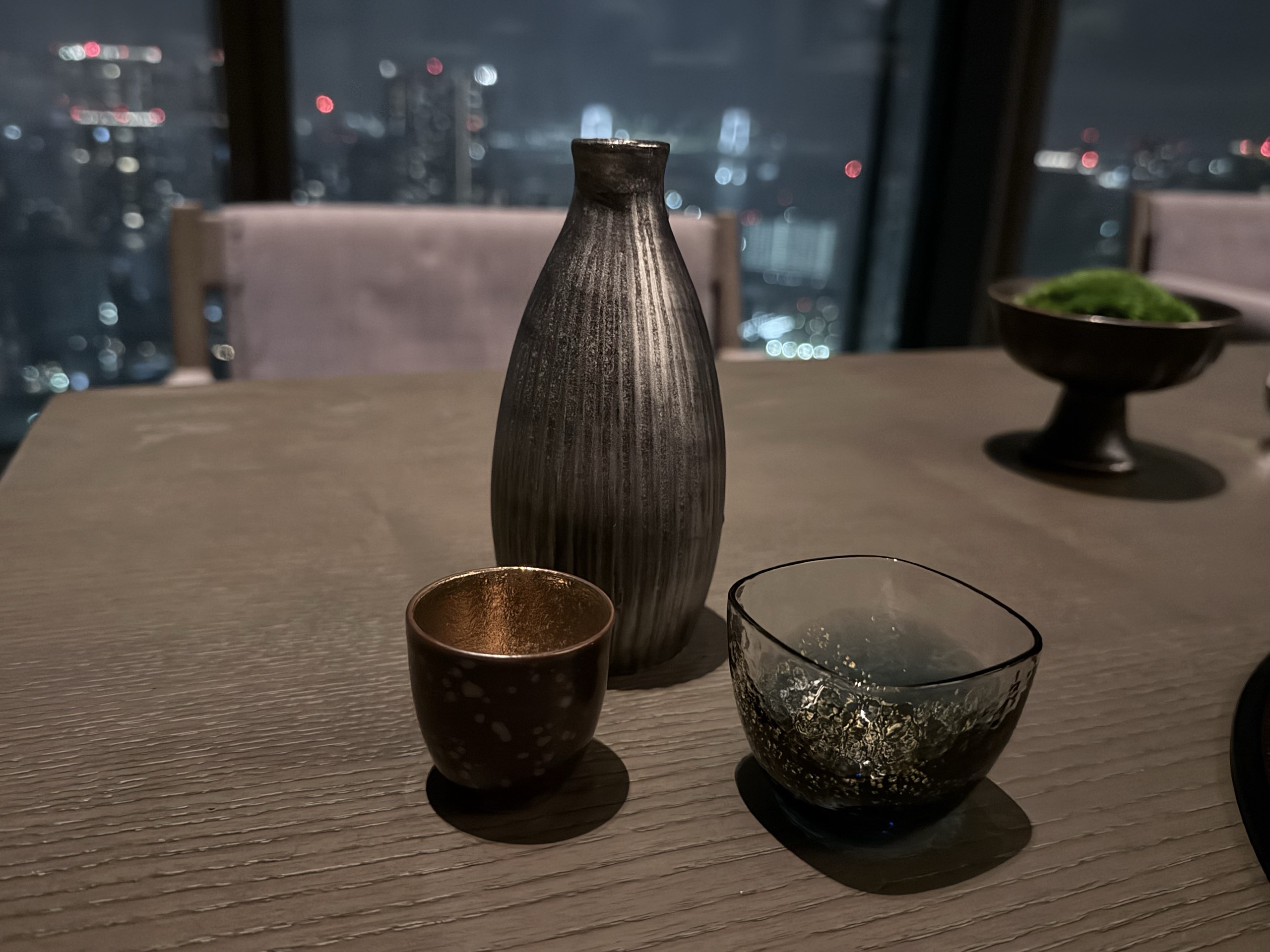 窓辺のテーブルの、徳利とお猪口、金粒入りのガラスの杯