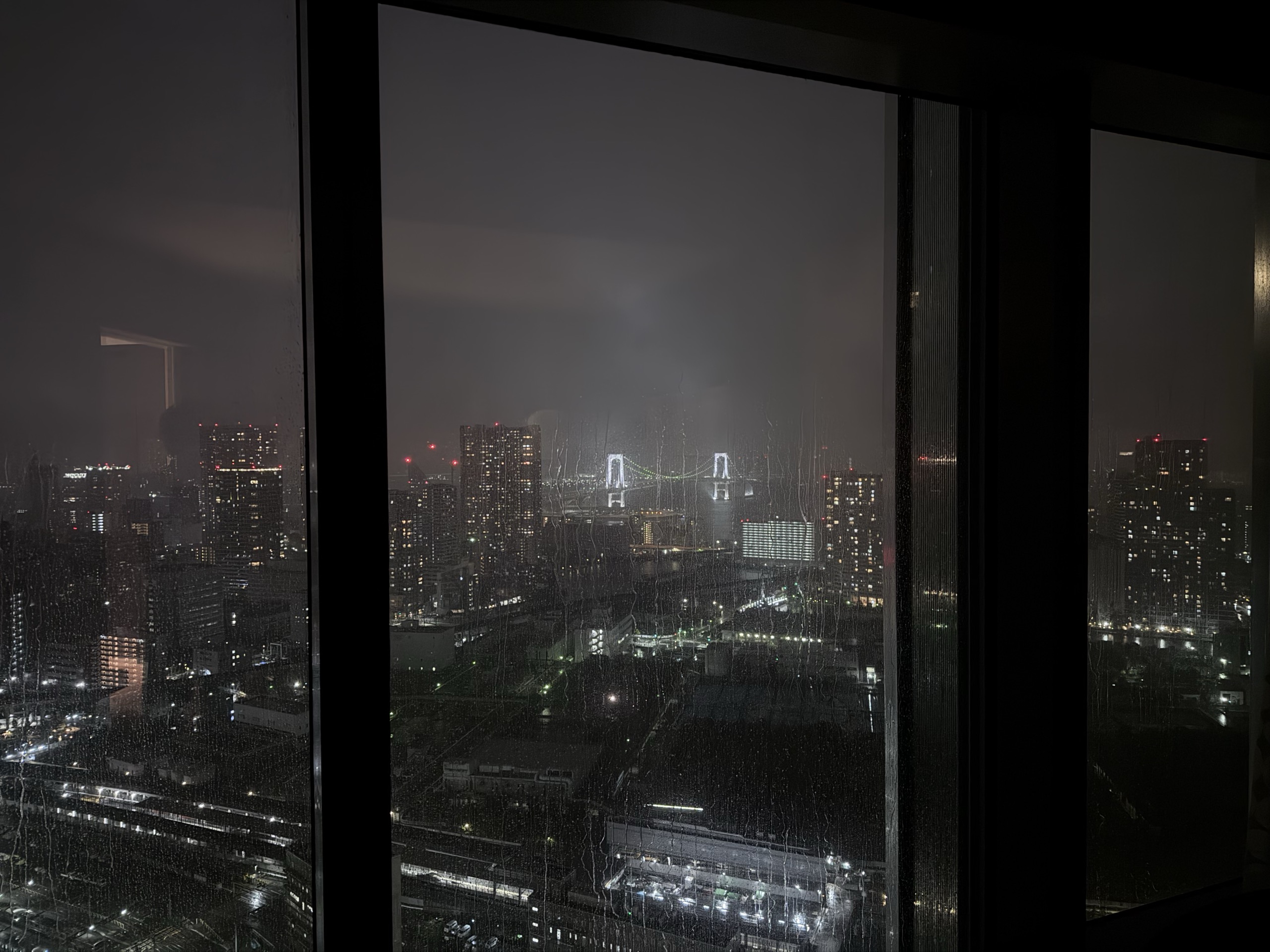 レインボーブリッジが見える、客室の窓からの雨の夜景
