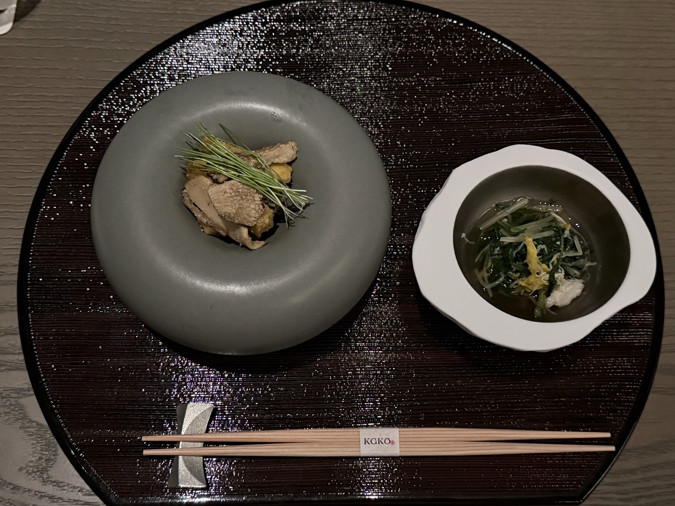 前菜の、灰緑の輪の形の器と、青菜と菊の花びらを浮かべた白い鉢の汁
