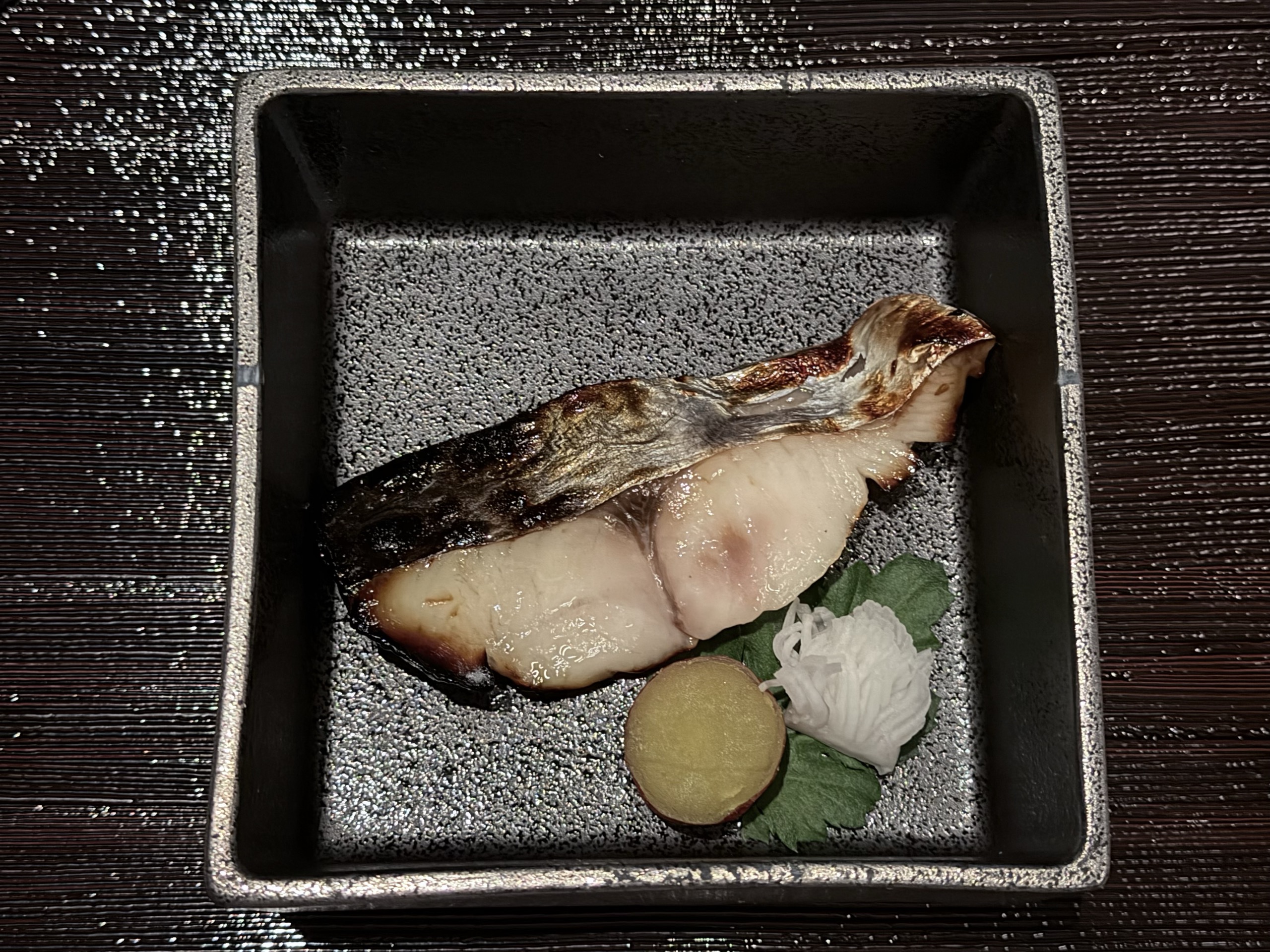 黒い角鉢の、皮目を焼いた白身の切り身