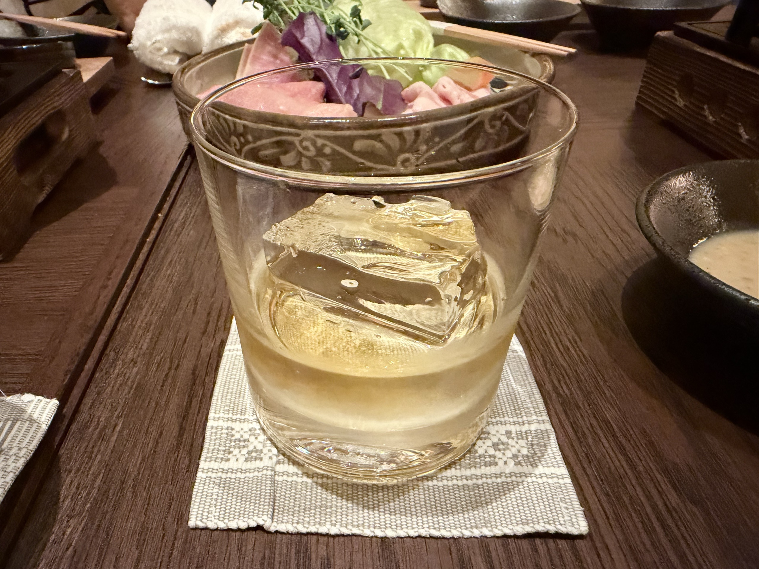 大きな氷を入れた、琥珀色の飲み物のグラス